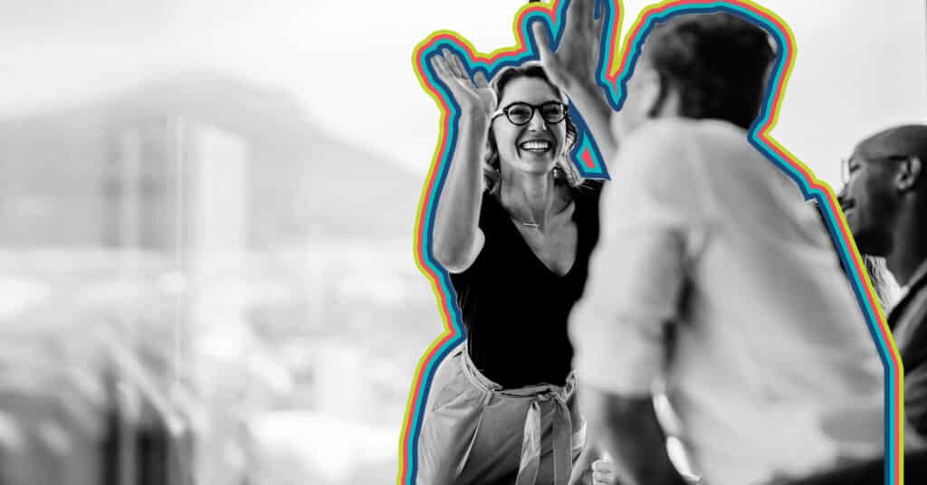 Two professionals celebrating after figuring out how to reduce customer attrition.