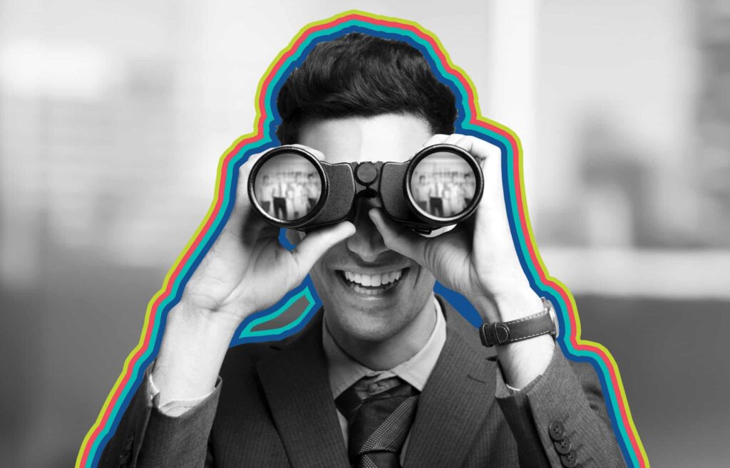 A man with binoculars searches for lower funnel keywords while smiling at the camera.