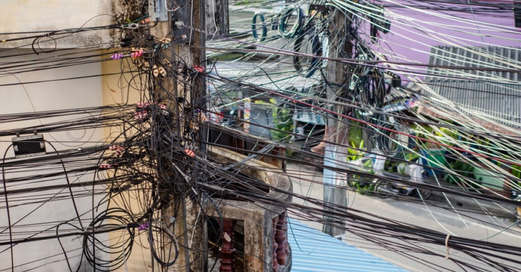 A jumble of telecommunications wires and cables illustrates the idea of complicated marketing automation migration.