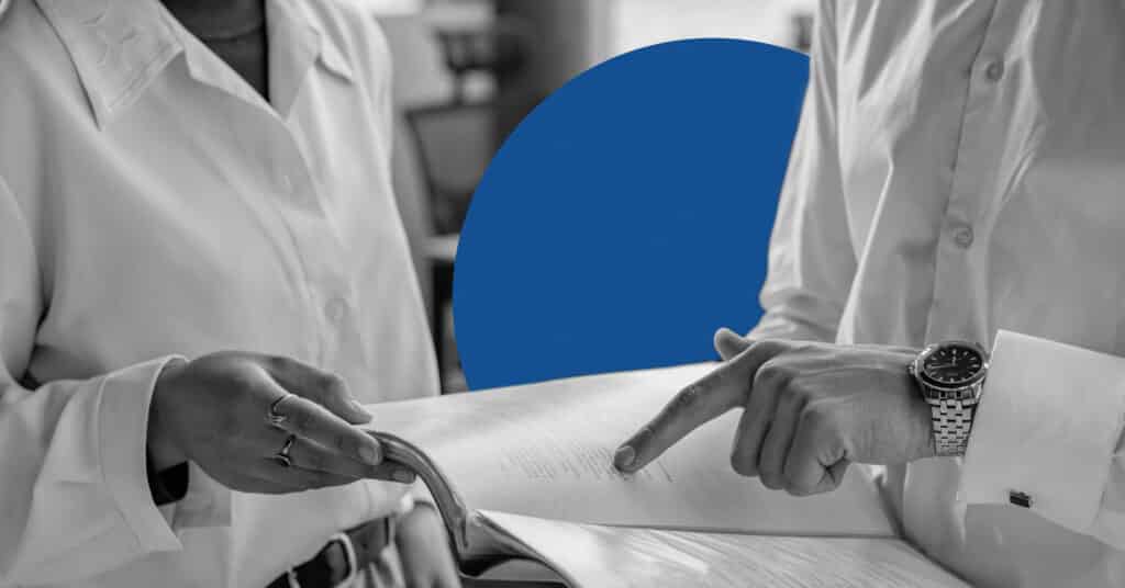 Close up of two business people examining documents to illustrate the concept of single source of truth.