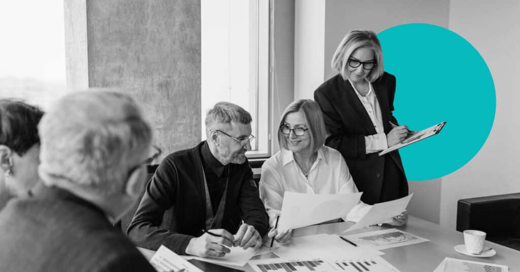 Medium shot of business meeting with professionals going over documents.