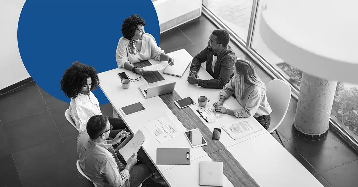 from overhead, a group of marketers works at a conference table