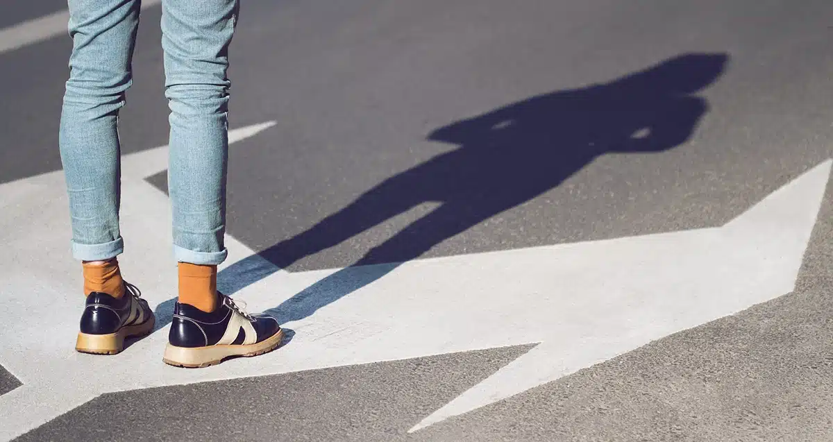 Customer Journey Mapping illustrated by a person standing on a crossroad.
