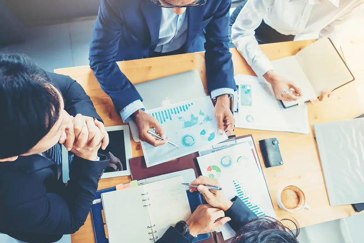 Marketers gathered at a table discussing how to improve marketing campaigns.